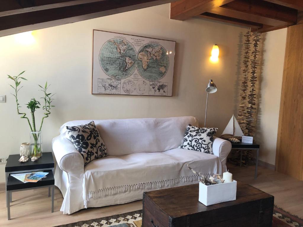 ein Wohnzimmer mit einem weißen Sofa und einem Tisch in der Unterkunft La plaza in Llanes