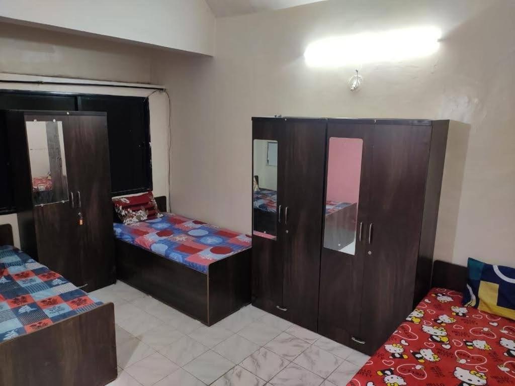 a room with two beds and wooden cabinets at sri rama krishna pg in Pune