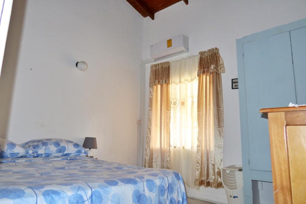 1 dormitorio con 1 cama y una ventana con cortinas en Elegant Rays Apartment- Golf Course , Grenada en Grand Anse