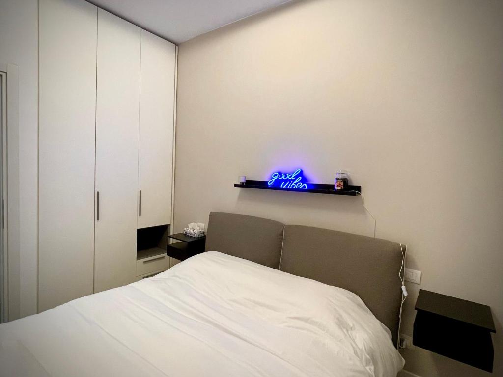 a bedroom with a bed and a neon sign on the wall at Sweet RHome - A due passi da San Pietro in Rome