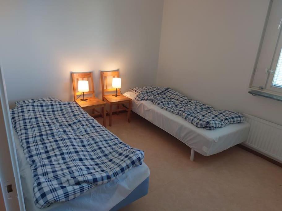 Dos camas en una habitación con dos lámparas. en Large Apartment, Quality Company Accommodation. en Sundsvall
