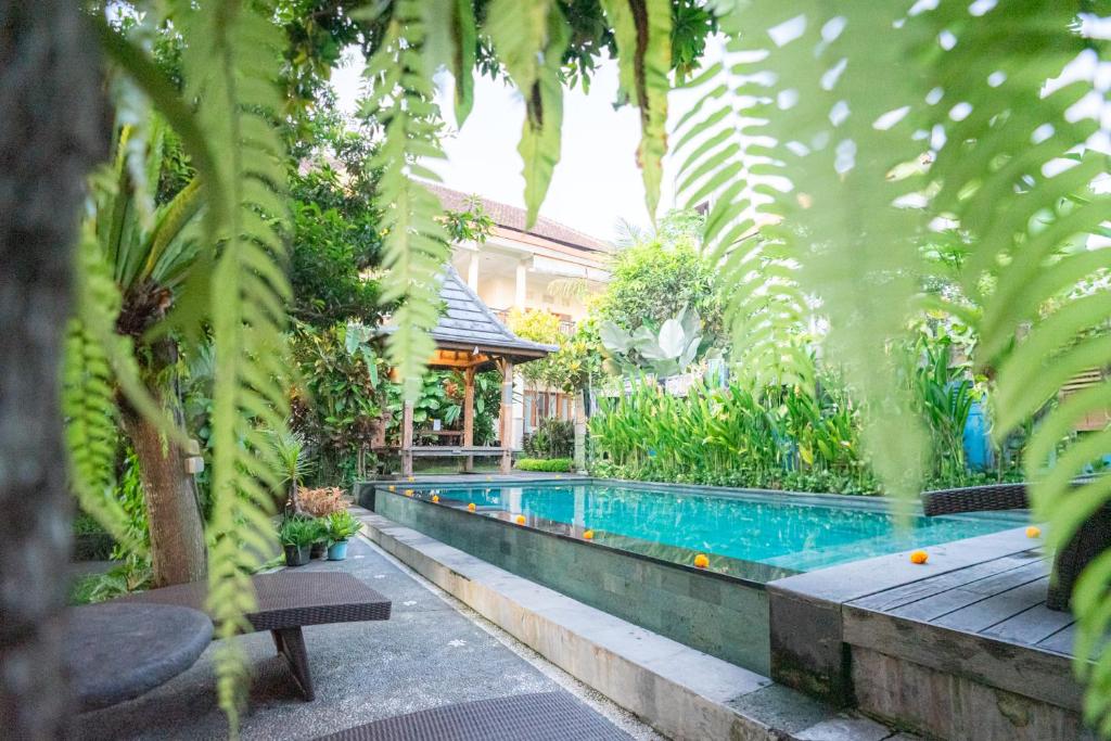 una piscina en un jardín con plantas en I Gusti Nyoman Oka Homestay, en Ubud