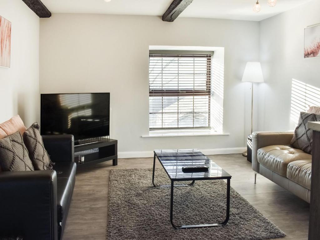 a living room with a couch and a coffee table at Beck Cottage in Millom