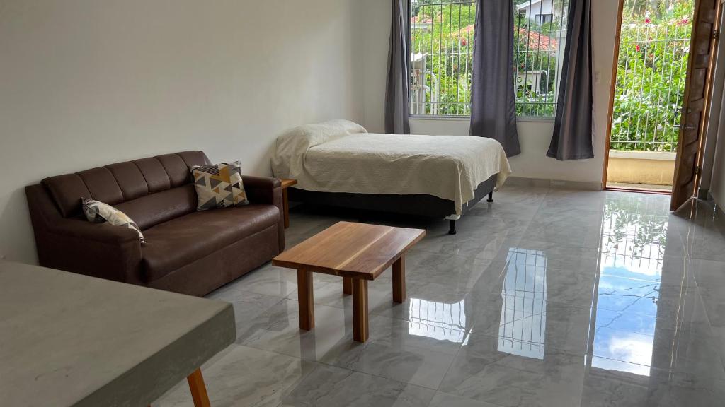 uma sala de estar com um sofá e uma cama em Hotel Bella em Tamarindo