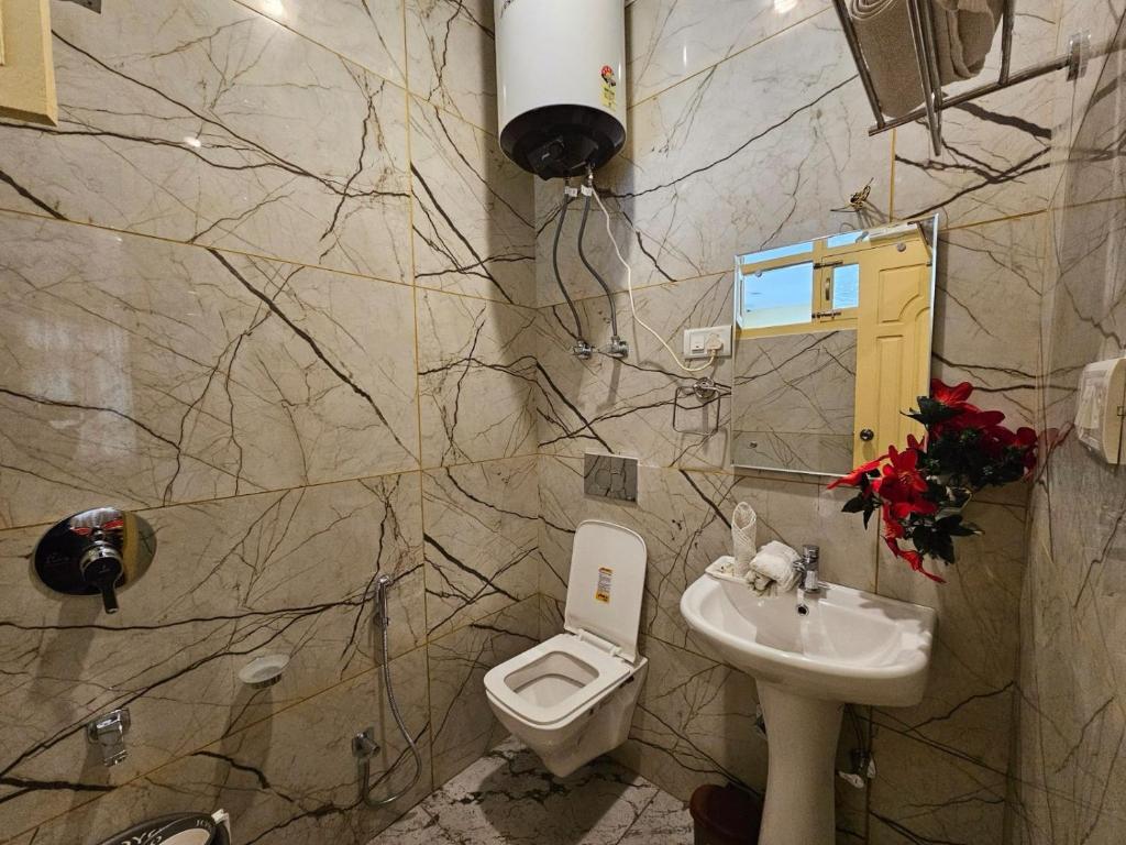 a bathroom with a toilet and a sink at Hotel Nouvella Residency in Srinagar