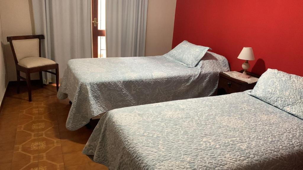 a hotel room with two beds and a chair at Excelente Ubicación in San Salvador de Jujuy