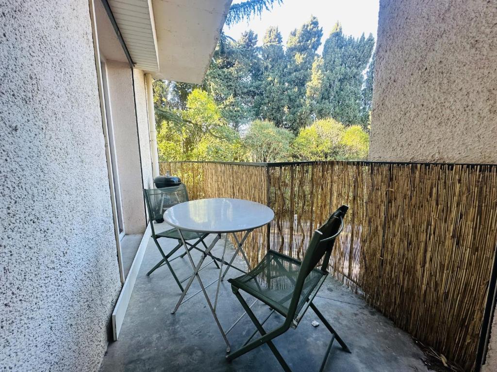 d'une table et de chaises sur un balcon avec une clôture. dans l'établissement Appartement T3 à Collioure, 200m de la plage, résidence calme avec parking et balcons - FR-1-309-417, à Collioure