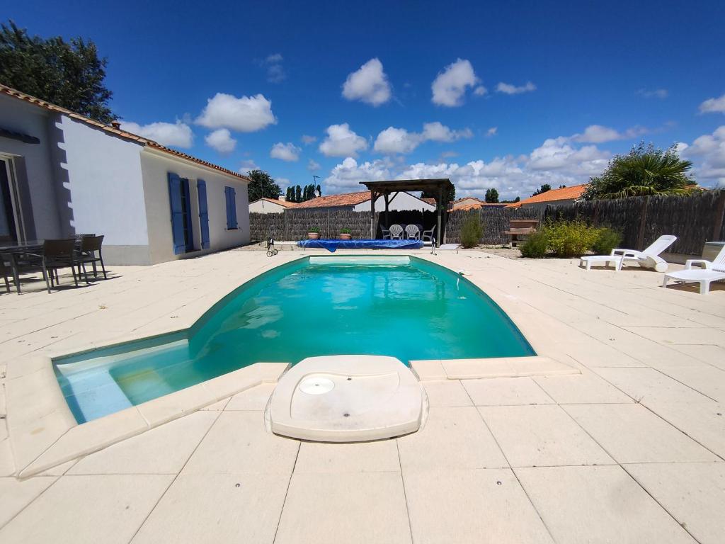 - une piscine au milieu d'un patio dans l'établissement Maison avec Piscine Privée, Jardin Clos et Parking proche Plage et Forêt à Saint Jean de Monts - FR-1-323-468, à Saint-Jean-de-Monts