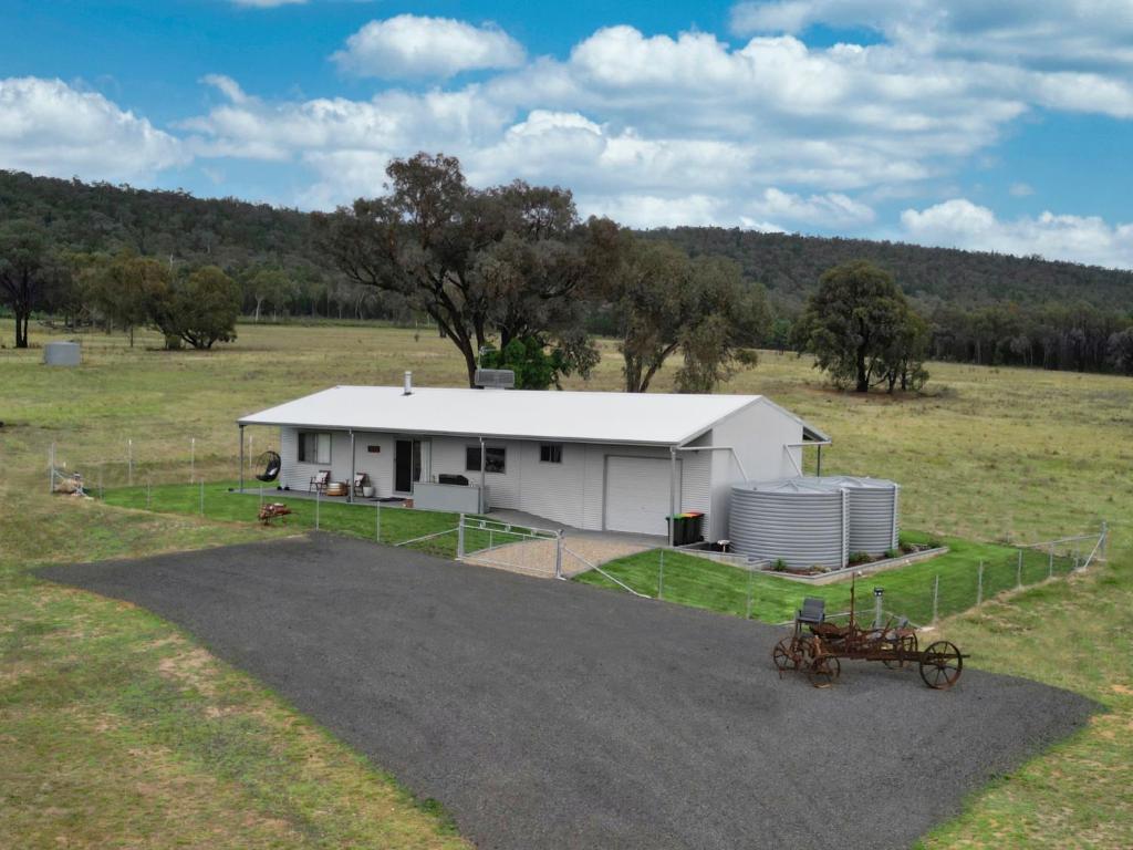 a large white building in the middle of a field at Kangarooby Cottage - A Peaceful Off-grid Escape 