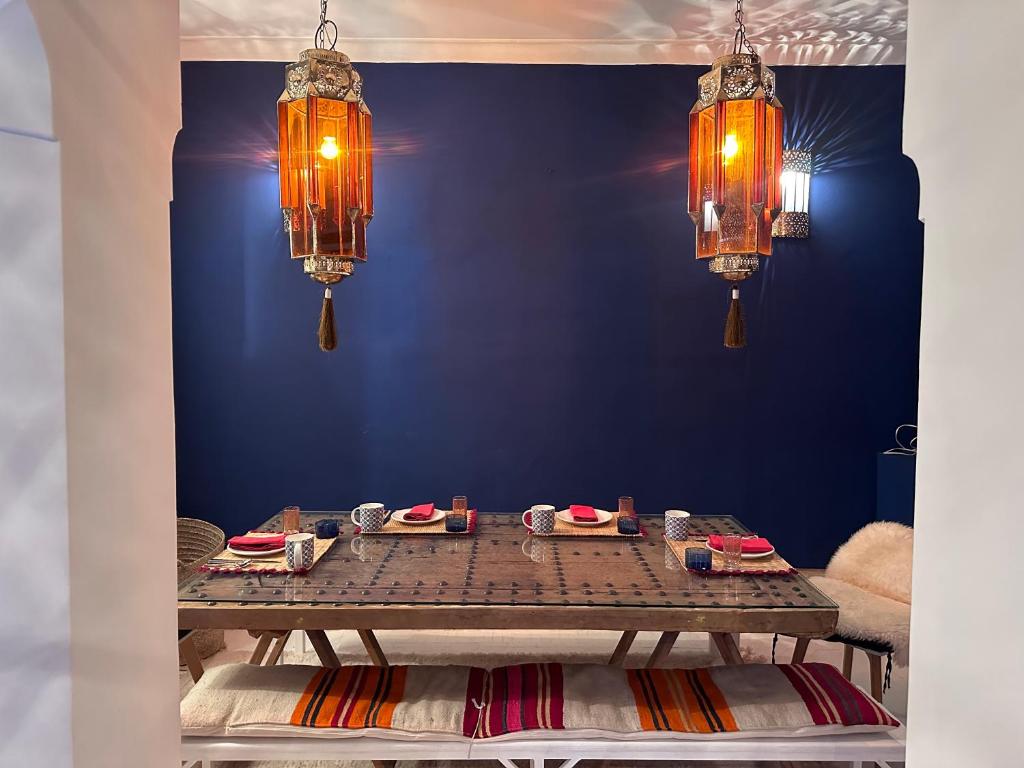 une table dans une pièce avec deux lustres dans l'établissement Berber Duchess Riad, à Marrakech