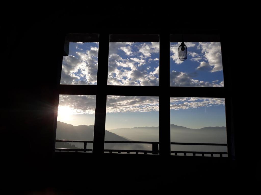 ein Fenster mit Blick auf den Himmel in der Unterkunft Family Homestay Darjeeling in Darjeeling