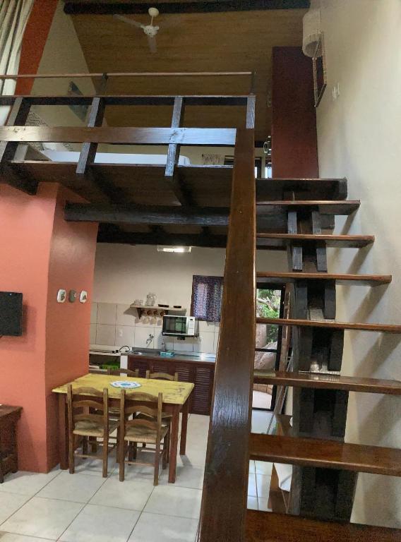 uma cozinha com uma escada em espiral de madeira num quarto em Chalé Aconchegante em Garopaba