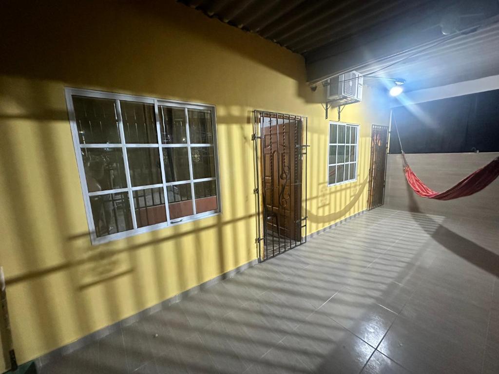Habitación con puerta y hamaca en la pared en Hostal el viajero en Soledad