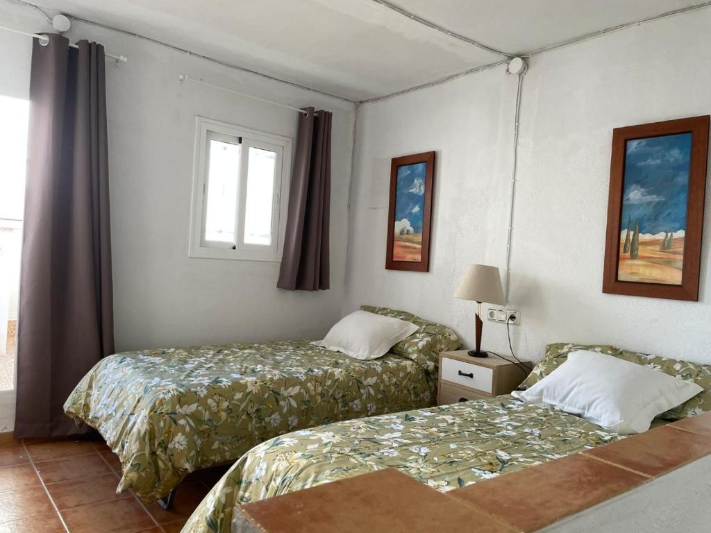 a hotel room with two beds and a window at Casita al completo en Montoro in Montoro