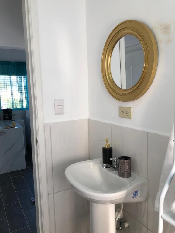ein Bad mit einem Waschbecken und einem Spiegel in der Unterkunft Apartamento en Gracias, Lempira -ARCITUR in Arsilaca