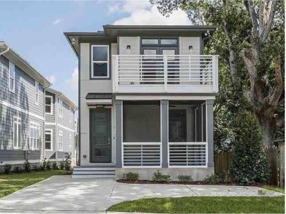 a white house with a porch and a balcony at City View- near Downtown, Capital, NC State in Raleigh