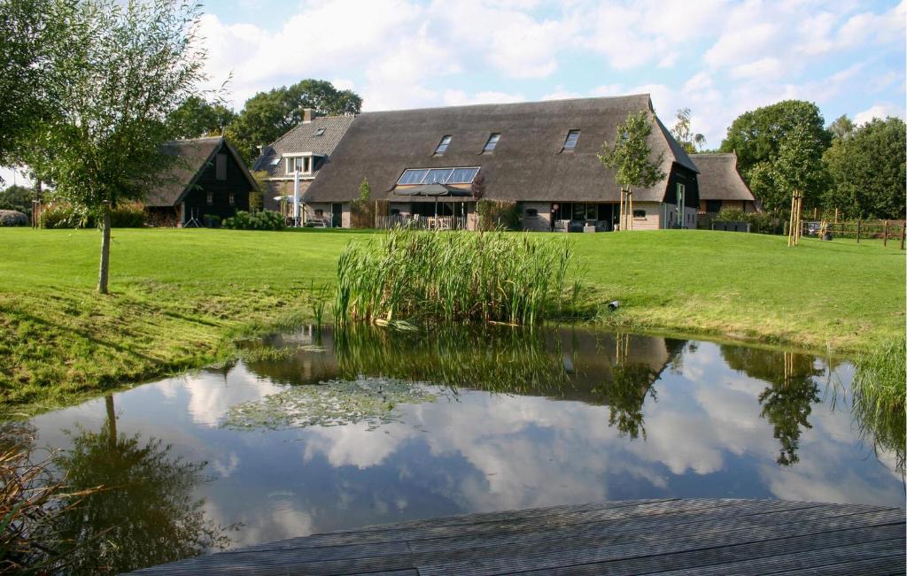ein Haus mit einem Teich davor in der Unterkunft Stunning Home In Dwingeloo With House A Panoramic View in Dwingeloo