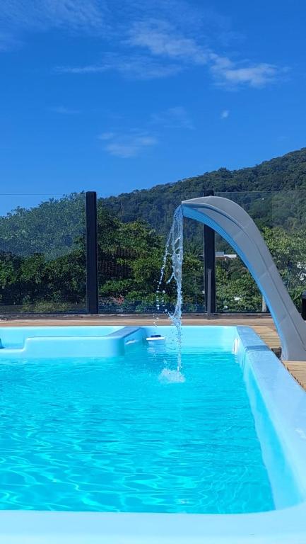 a swimming pool with a water slide in it at Pousada do Francês in Ubatuba