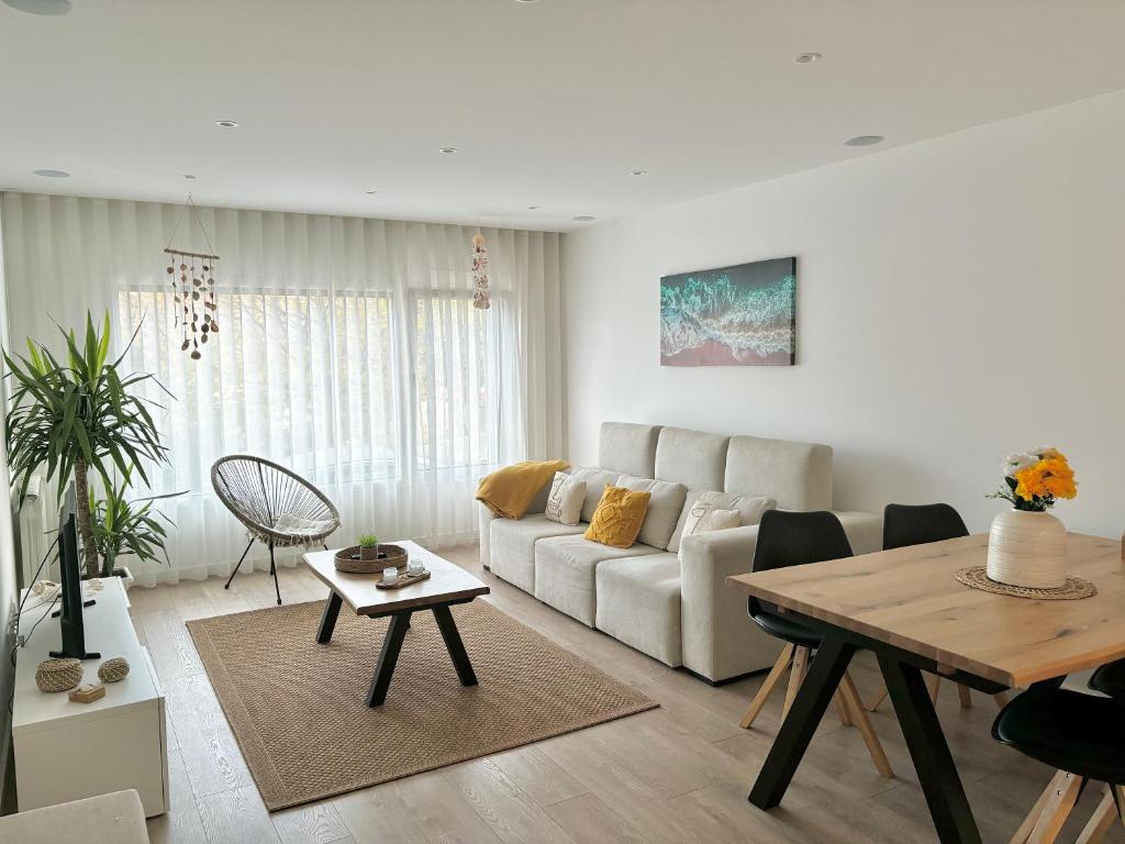 een woonkamer met een bank en een tafel bij Moodhu Villa - Cozy Apart w/ Amazing Terrace in Leiria