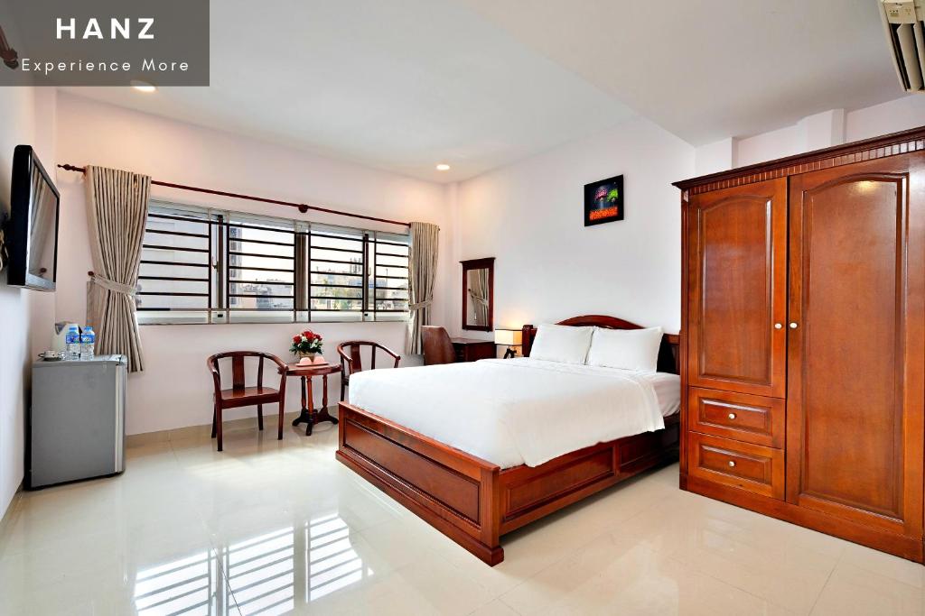 1 dormitorio con 1 cama grande y 1 mesa en HANZ Hoang Hoang Hotel Ben Thanh en Ho Chi Minh