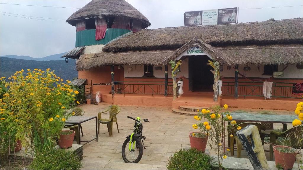 a bike parked in front of a house with flowers at Astam farm house homestay in Pokhara
