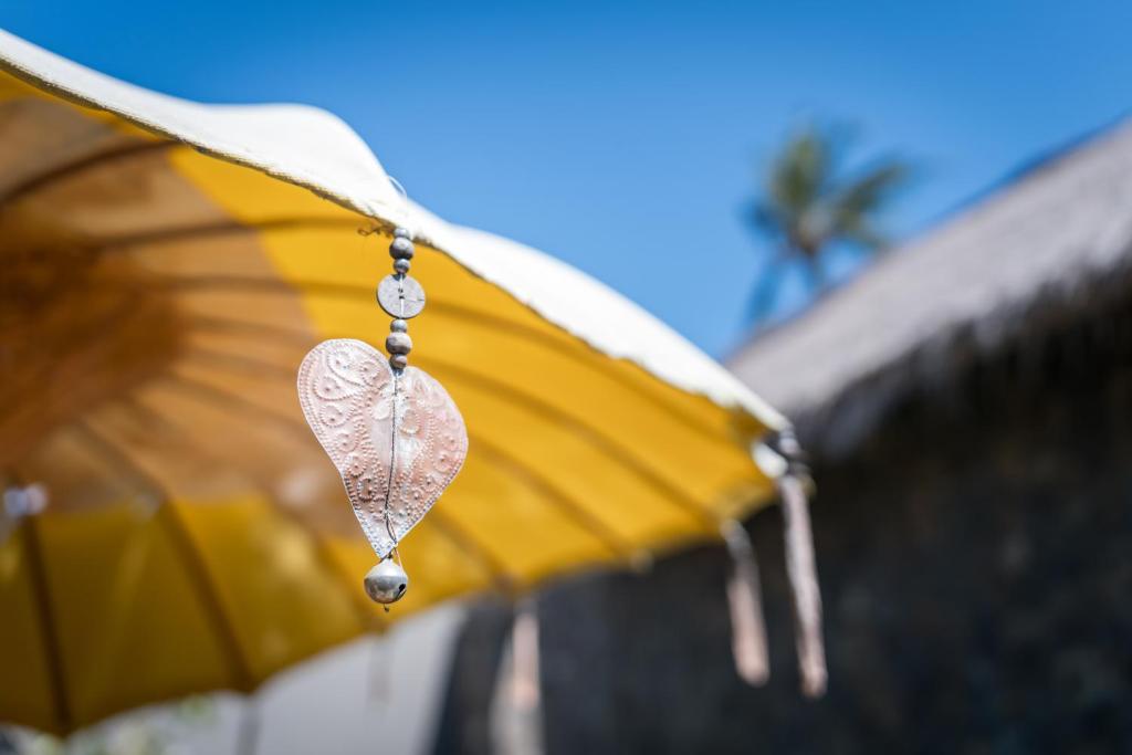 a heart ornament hanging from a yellow umbrella at Flow Gili Air in Gili Air