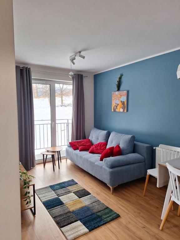 sala de estar con sofá y pared azul en SUNNY HILL , KOWARY, en Kowary