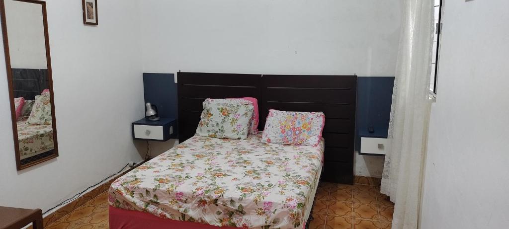 een bed met twee kussens in een kamer bij Casa praia grande in Praia Grande