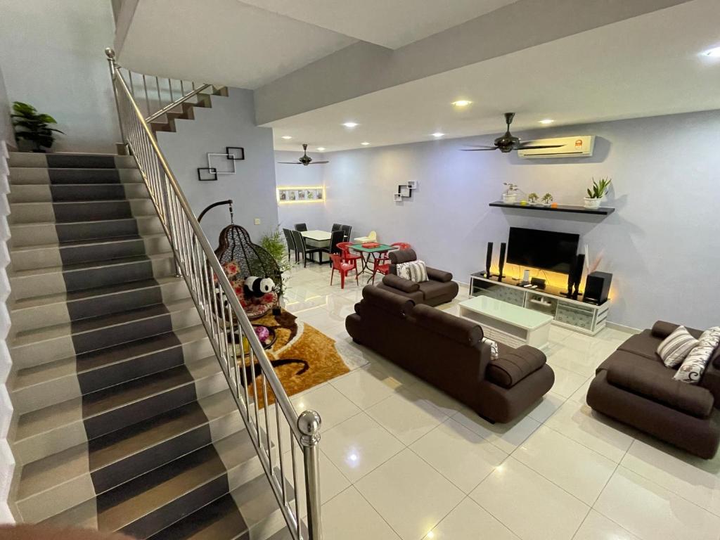 a living room with a staircase and a fireplace at JJ&KK Homestay in Simpang