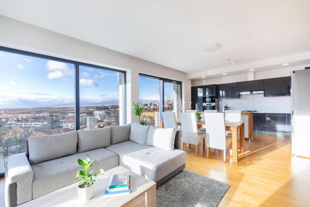 a living room with a couch and a dining room at Airport Luxury Apartment Prague in Prague