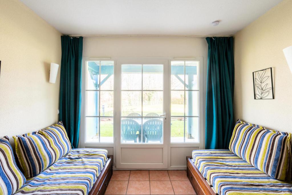 un salon avec deux canapés et une fenêtre dans l'établissement Résidence Les Belles Rives - maeva Home - Appartement 2 pièces 5 personnes - Confort MAE-4384, à Argentat