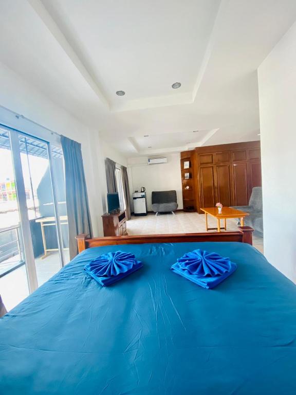 een slaapkamer met een blauw bed met blauwe kussens erop bij BT hotel Kata Beach in Kata Beach