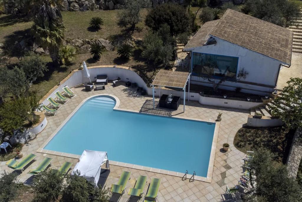 een uitzicht op een zwembad naast een huis bij Stunning apartment in the nature with dreamy view in Parrinello 