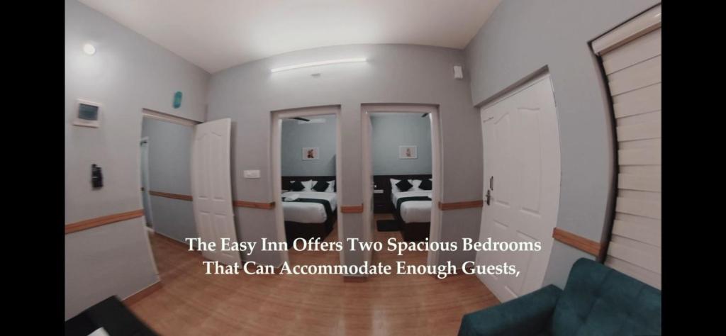 an empty room with two beds and a room with at Easy Inn Wayanad in Kaniyāmbetta