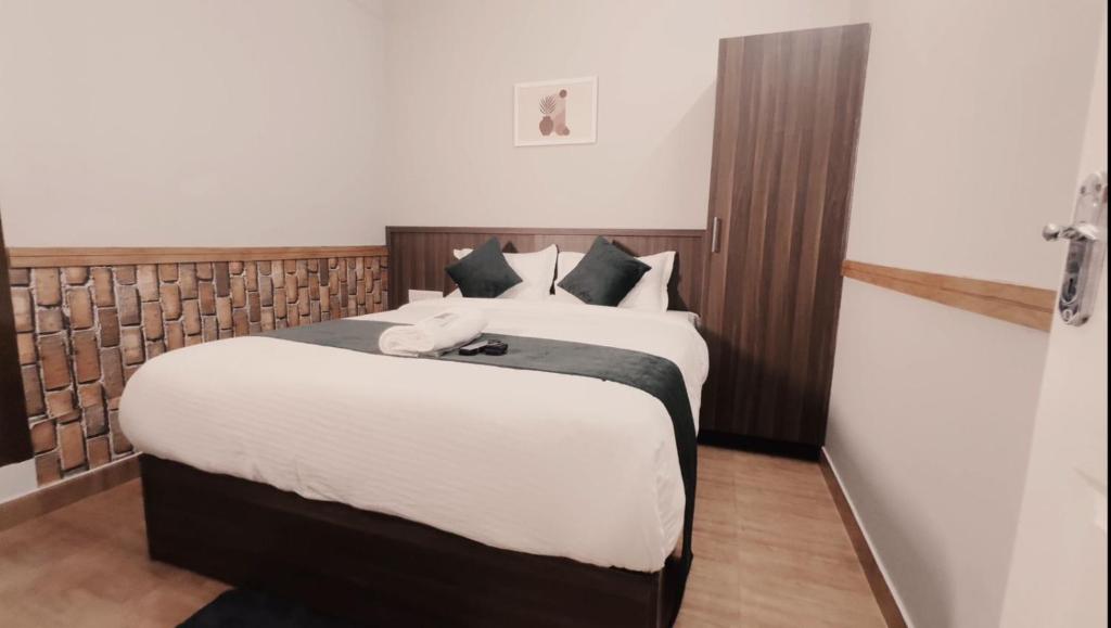 a bedroom with two beds with white sheets at Easy Inn Wayanad in Kaniyāmbetta