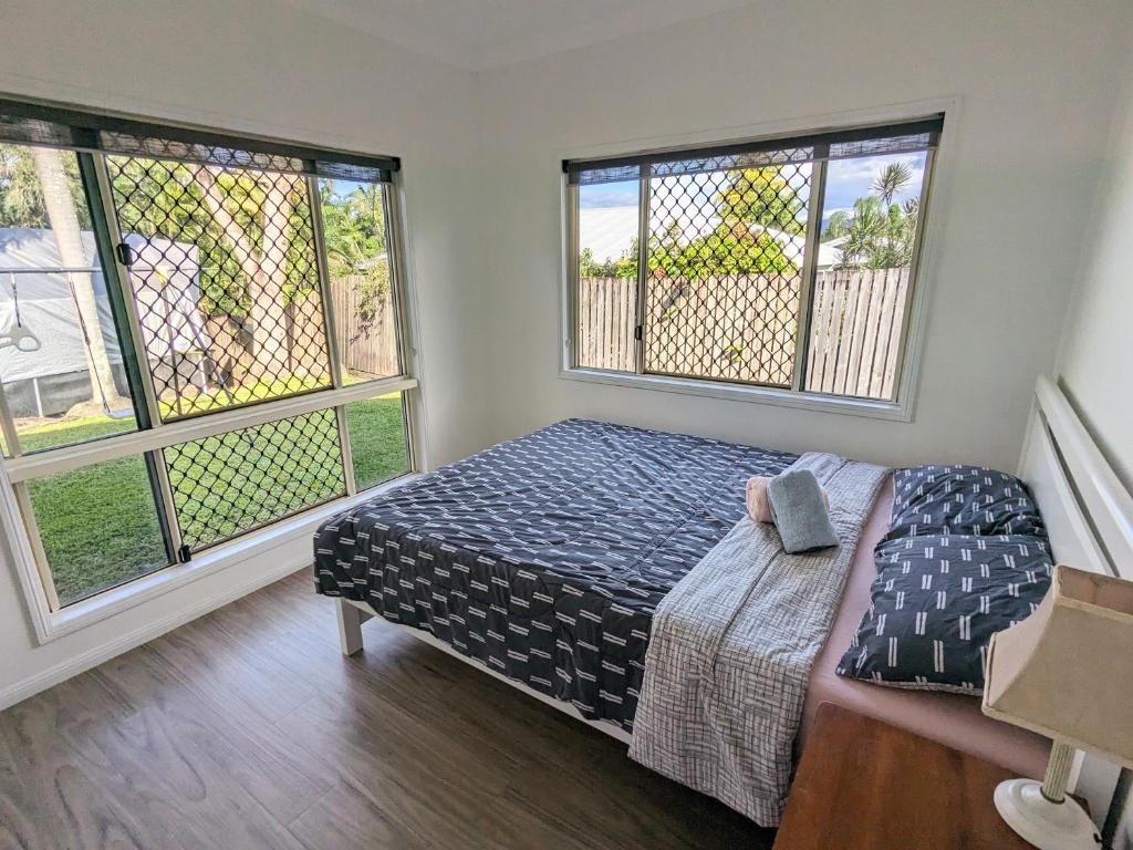 a bedroom with a bed and two windows at One bedroom in Mount Sheridan in White Rock
