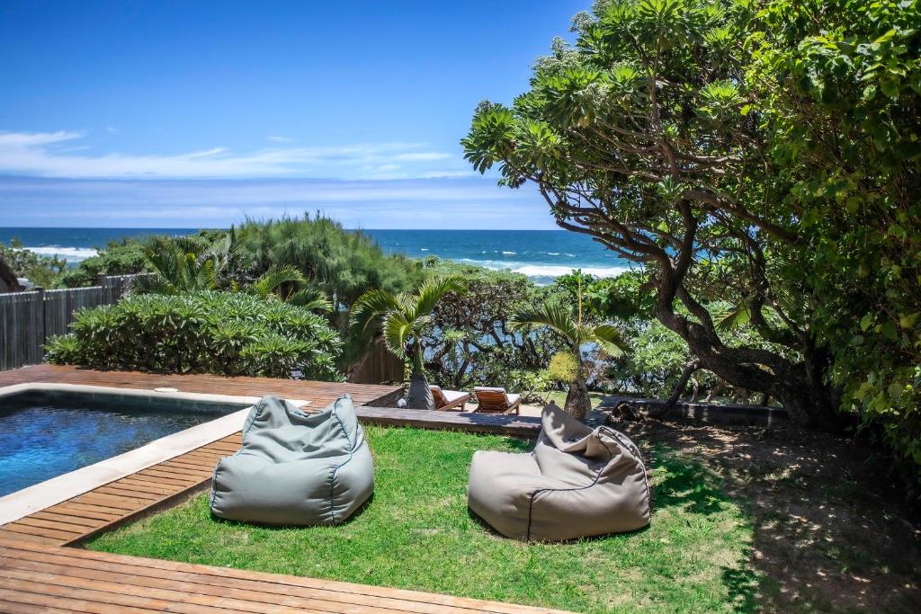 a backyard with a swimming pool and a lawn with inflatable chairs at Beach Villa Poema in Centre de Flacq