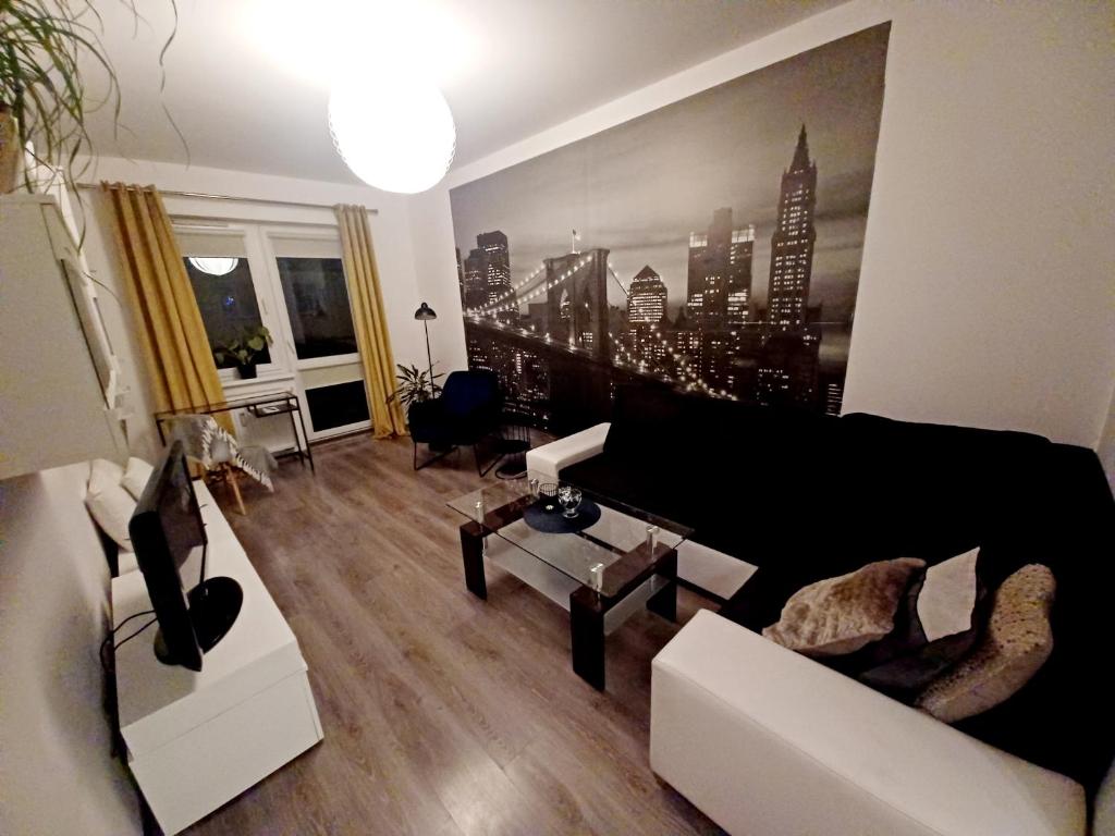 a living room with a black couch and a table at Między miastem a naturą Niebieski Zakątek in Olsztyn