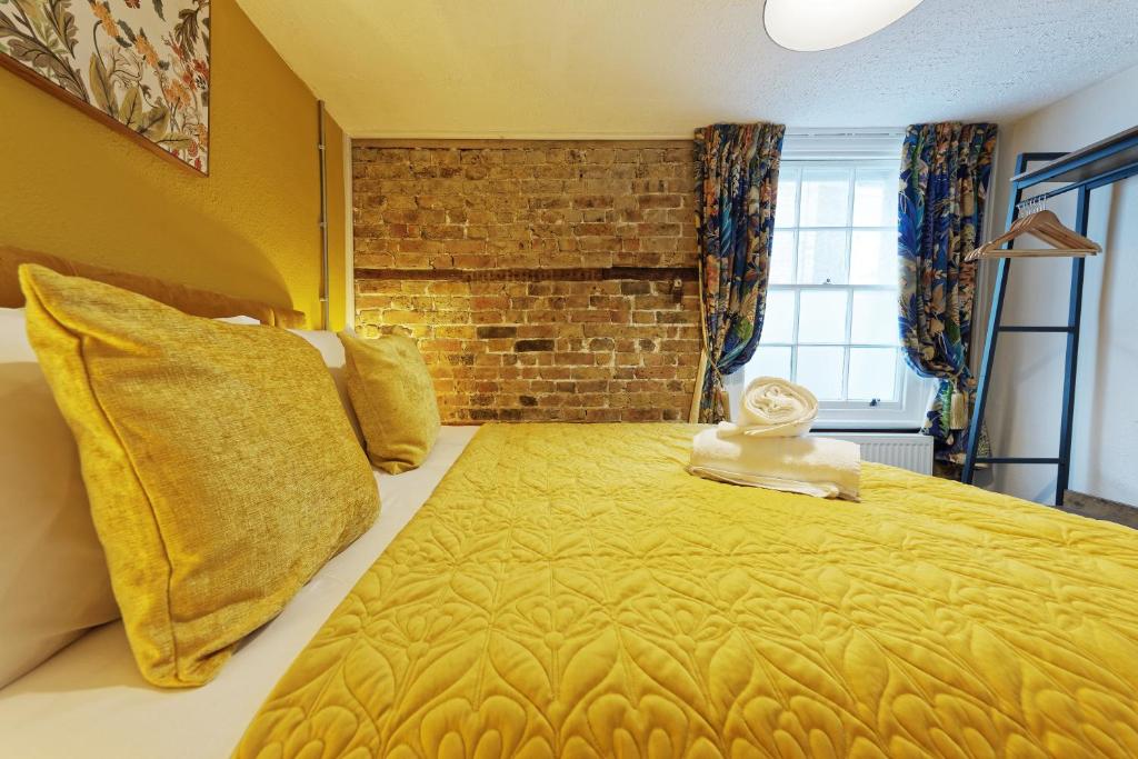 a bedroom with a large bed with a brick wall at Northern Belle four Bedroom Apartment in Margate