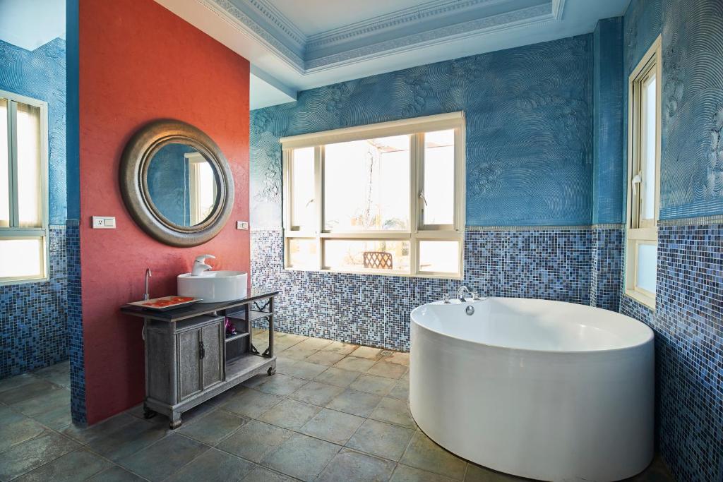 a large bathroom with a tub and a sink at Sharjah B&amp;B in Wujie