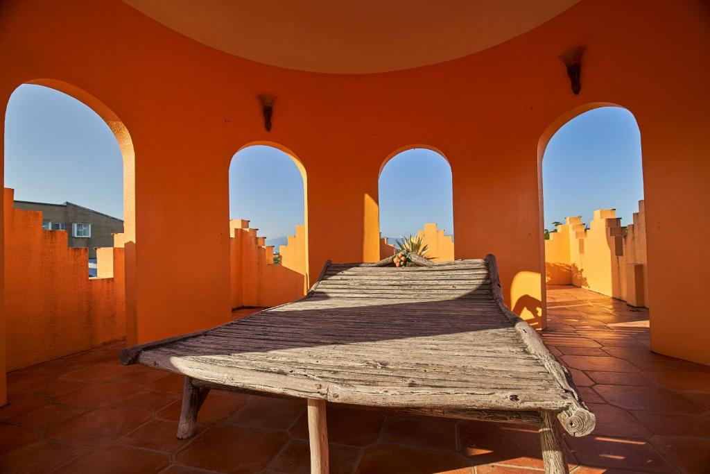 a bed in a room with orange walls and windows at Sharjah B&amp;B in Wujie