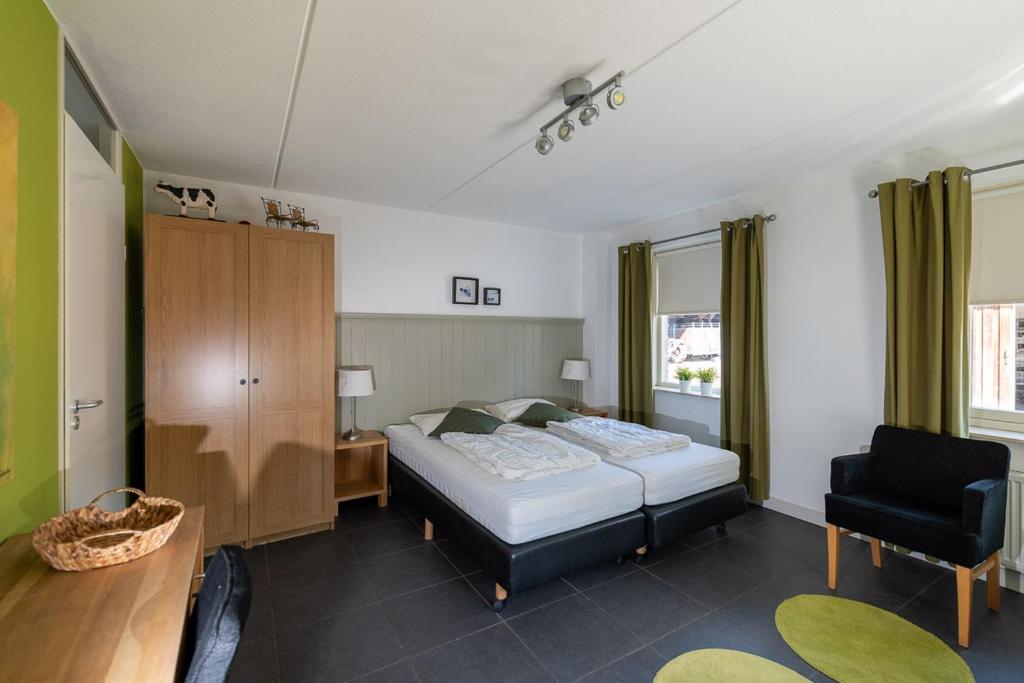 - une chambre avec un lit et une chaise dans l'établissement Hoeve Montigny B&B, à Giethoorn