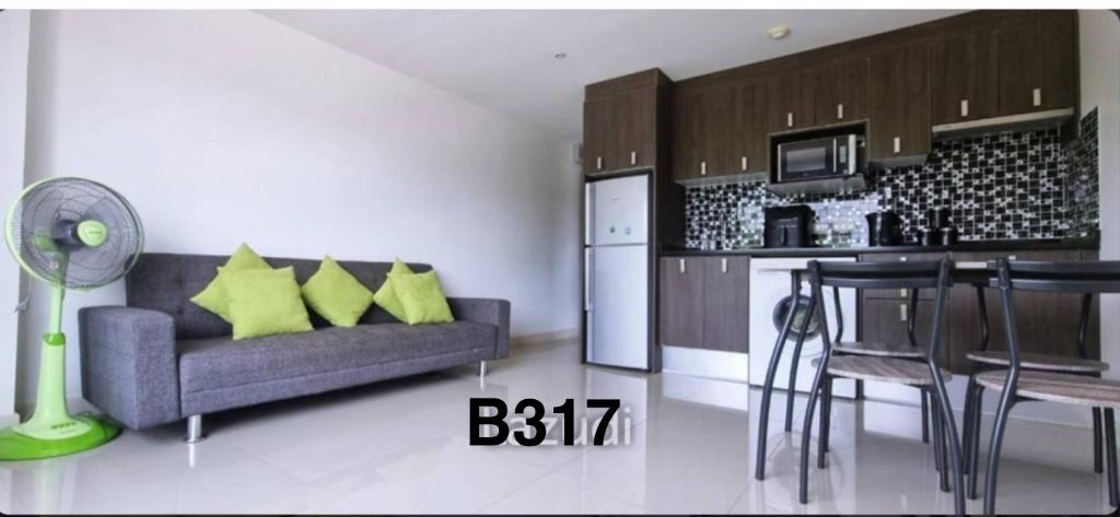 een woonkamer met een bank en een keuken bij Bangsaray Beach Resort in Bang Sare