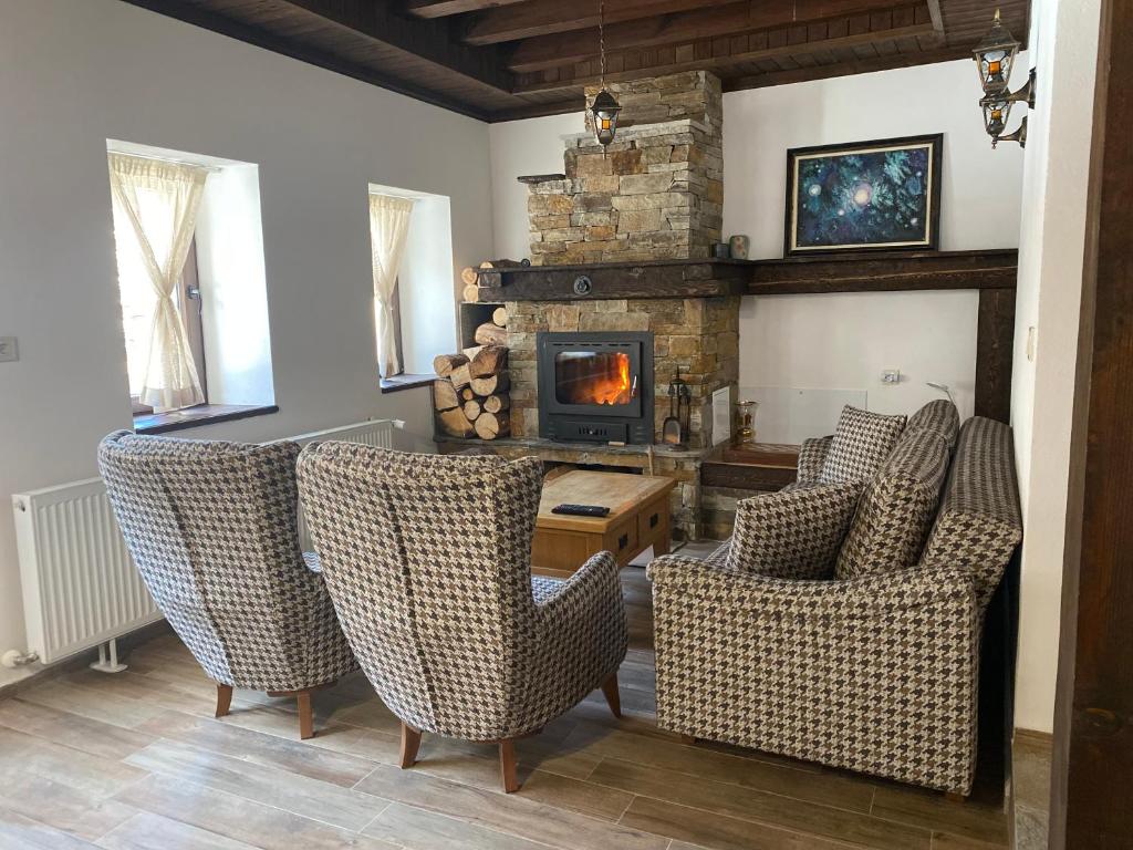 a living room with chairs and a stone fireplace at Star Dust in Shiroka Lŭka