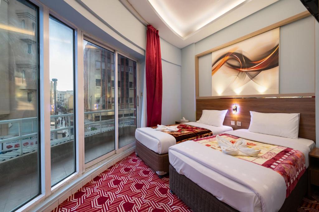 a hotel room with two beds and a window at Tanha Hotel in Dubai
