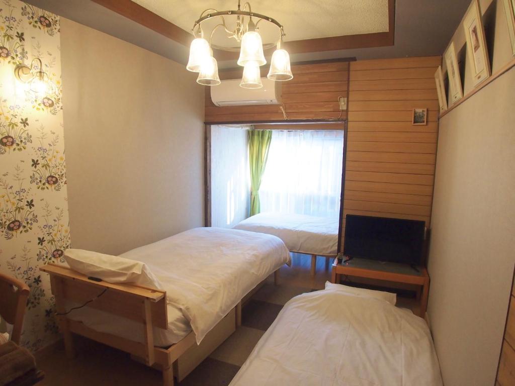 Habitación pequeña con 2 camas y ventana en Classy仏生山, en Takamatsu