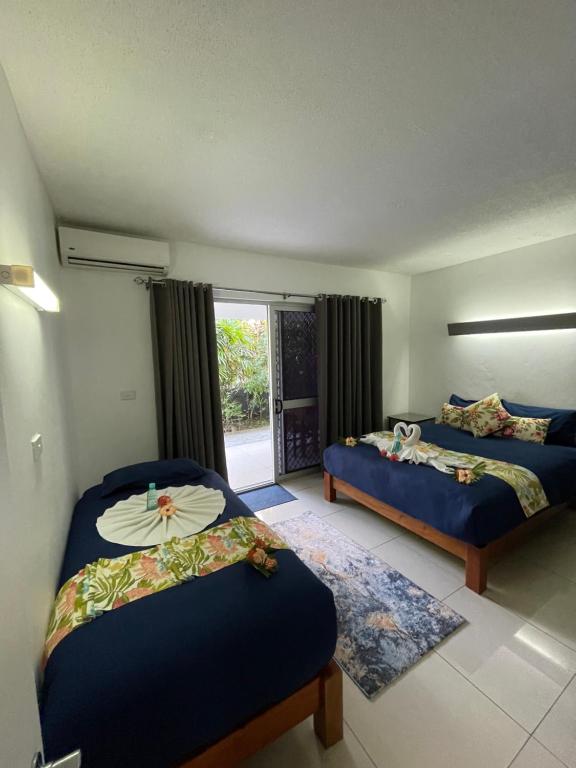a bedroom with two beds and a window at Island Accommodation Suva Premier Hospitality in Suva