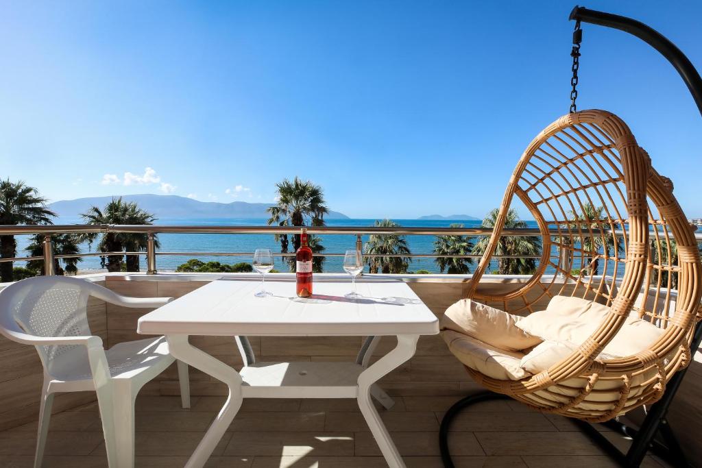 a white table and chairs on a balcony with the ocean at Jimi Apartments 2 in Vlorë