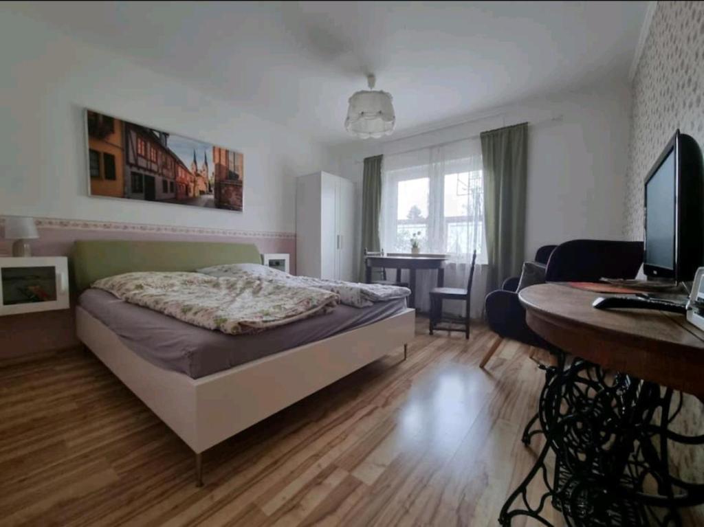 a bedroom with a bed and a desk with a computer at Fewo Neuruppin Einliegerwohnung in Neuruppin