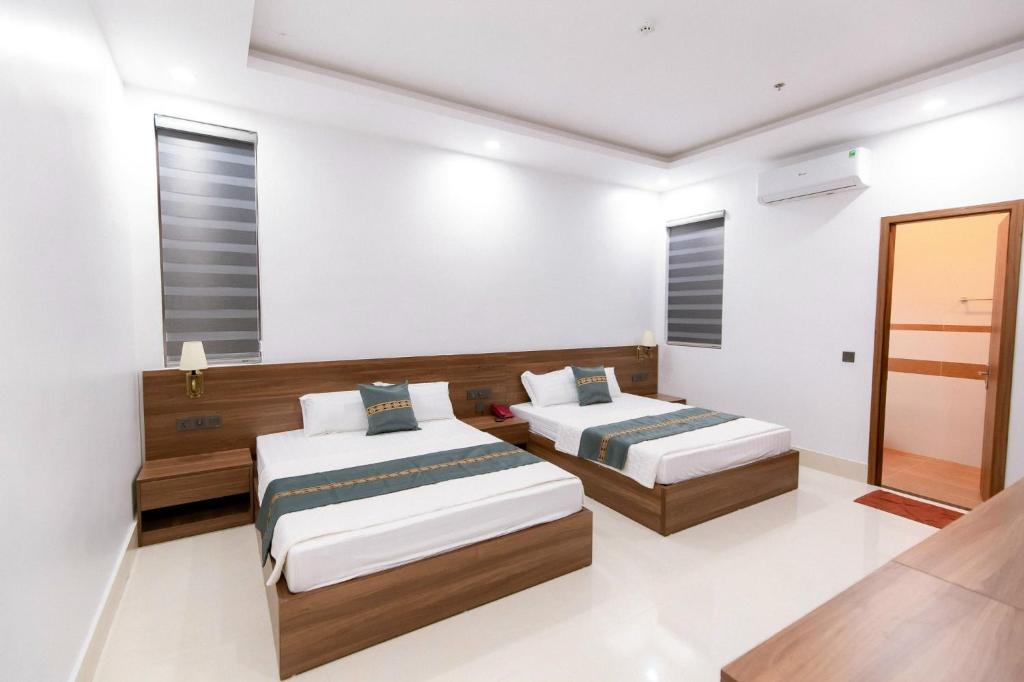 A bed or beds in a room at Khách sạn Vạn Phúc - Yên Bái